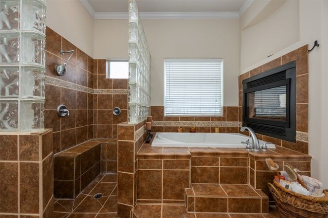 With the fireplace overlooking the tub, the space is warm and accessible, with the walk in shower next to it. | Image 14