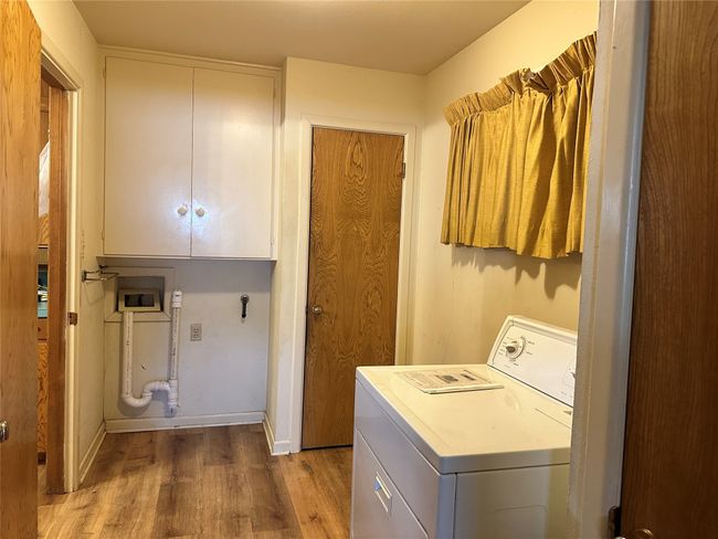 Washroom featuring washer / clothes dryer, wood finished floors, and baseboards | Image 14