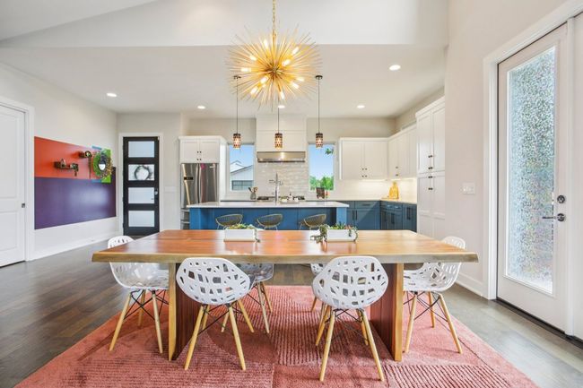 Dining room with dark wood finished floors, plenty of natural light, recessed lighting, and a chandelier | Image 11