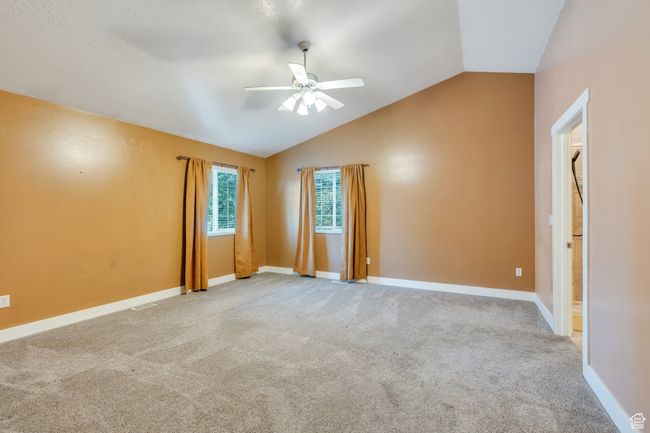 Spare room with vaulted ceiling, baseboards, carpet, and ceiling fan | Image 9