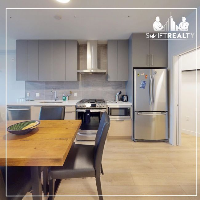 Kitchen featuring gray cabinets, modern cabinets, a sink, wall chimney exhaust hood, and appliances with stainless steel finishes | Image 5