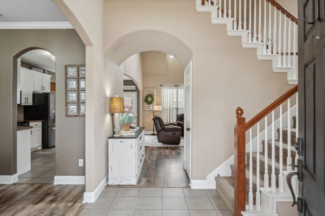 Foyer featuring light tile patterned floors, arched walkways, and baseboards | Image 4