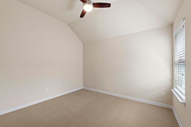 Unfurnished room featuring lofted ceiling, a ceiling fan, and light colored carpet | Image 31