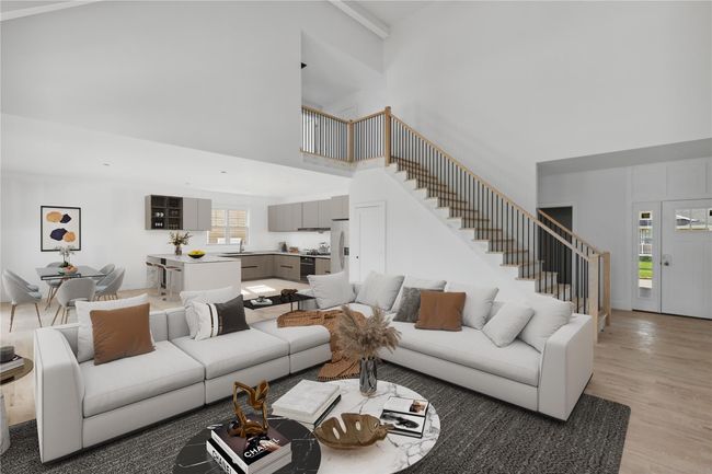 Living room featuring light wood-style floors, a towering ceiling, and stairs | Image 4