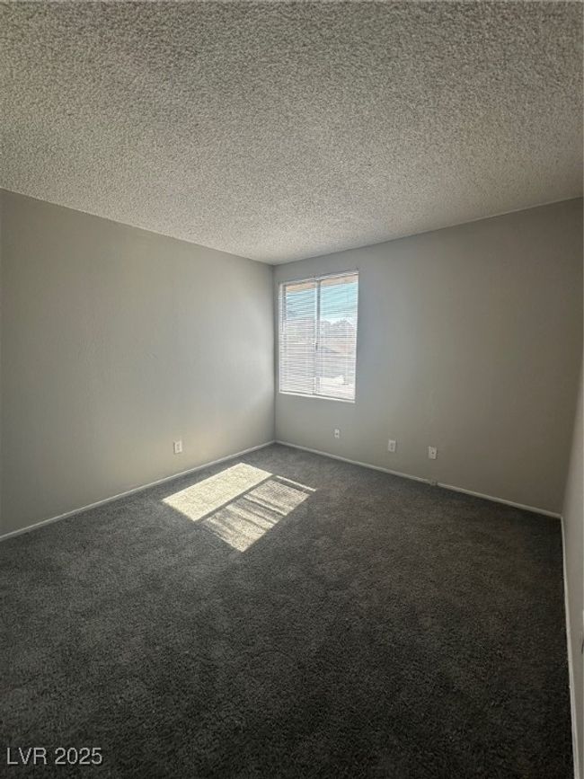 Empty room with carpet, a textured ceiling, and baseboards | Image 13