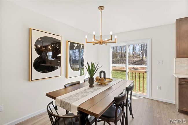 Dining room featuring a chandelier, light wood-style flooring, and baseboards | Image 13