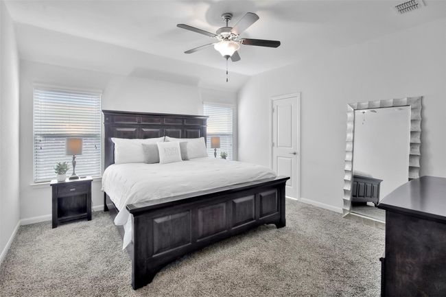 Bedroom featuring light carpet, baseboards, a ceiling fan, and lofted ceiling | Image 13