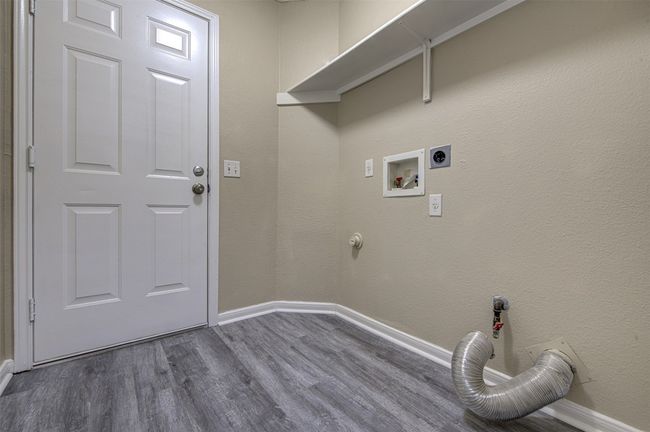 Laundry area with hookup for an electric dryer, dark wood finished floors, gas dryer hookup, and hookup for a washing machine | Image 10