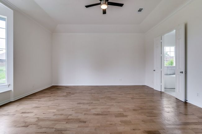 Spare room featuring healthy amount of natural light, a ceiling fan, wood finished floors, and baseboards | Image 14