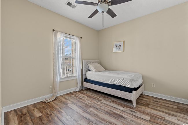 Bedroom featuring wood finished floors, baseboards, ceiling fan, and visible vents | Image 18