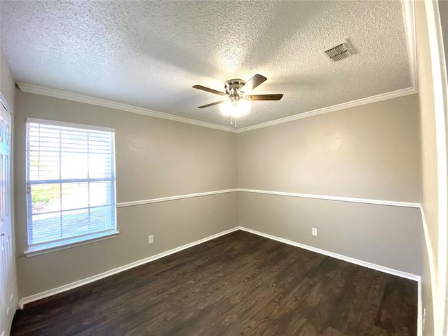 8836 Bedroom featuring ornamental molding, ceiling fan, dark wood-style floors, and a textured ceiling | Image 24