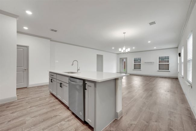 Kitchen featuring a sink, visible vents, stainless steel dishwasher, and a center island with sink | Image 10