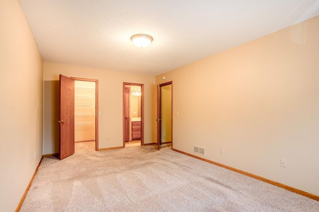 Direct access to a walk-in closet and ensuite bath makes this primary suite a comfortable and functional retreat. | Image 17