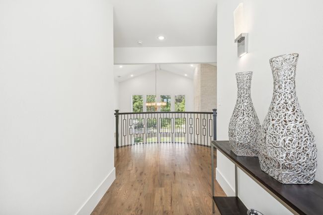 Hall featuring a chandelier, wood finished floors, recessed lighting, and high vaulted ceiling | Image 23