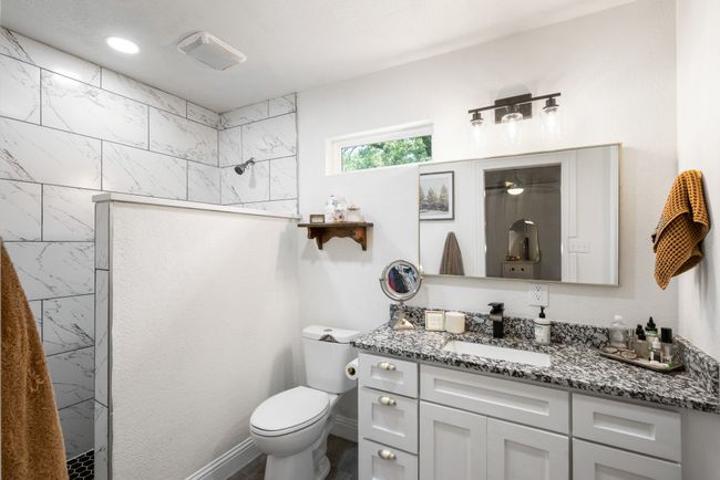 Bathroom featuring vanity and tiled shower | Image 18