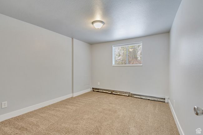 Unfurnished room with carpet floors, baseboard heating, a textured ceiling, and baseboards | Image 10