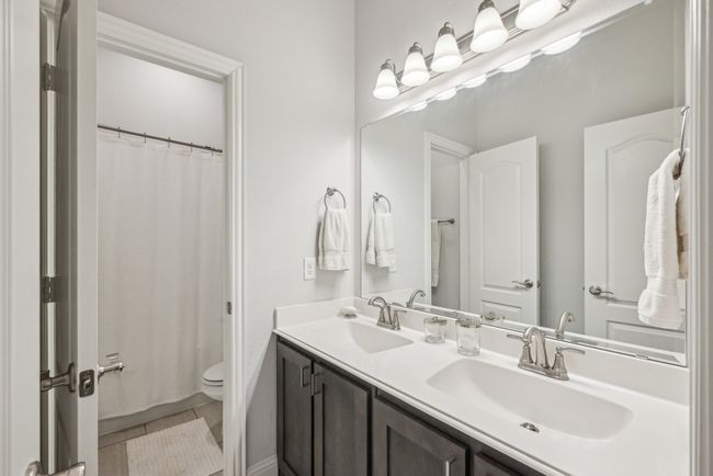 Bathroom with double vanity, door leading to tub/toilet. Locating in the hallway adjacent to the secondary additional bedrooms and laundry room | Image 30