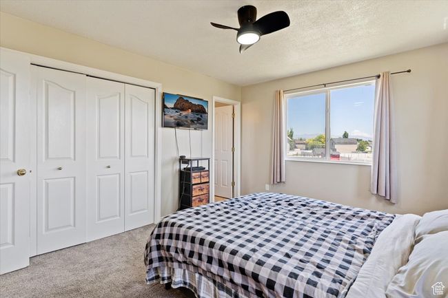 Bedroom featuring carpet floors, baseboards, a textured ceiling, and a ceiling fan | Image 13