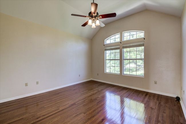 Bedroom 3. Front facing bedroom with vaulted ceiling, hardwood floors and views of the oak trees and front yard. | Image 19