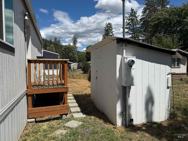 View of side of home with a wooden deck and a shed | Image 23