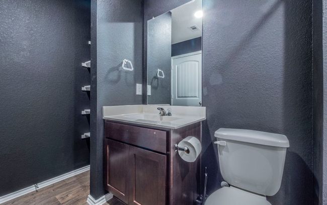 Half bath with wood finished floors, a textured wall, and vanity | Image 17