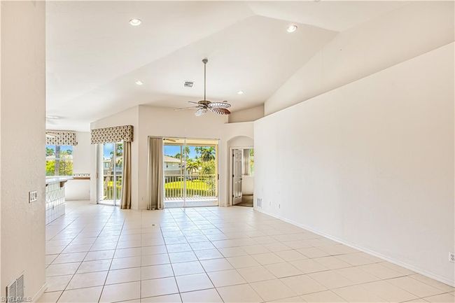 Tiled spare room featuring baseboards, ceiling fan, vaulted ceiling, recessed lighting, and arched walkways | Image 10