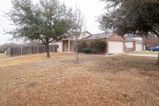 View of front of house featuring driveway, brick siding, and an attached garage | Image 30