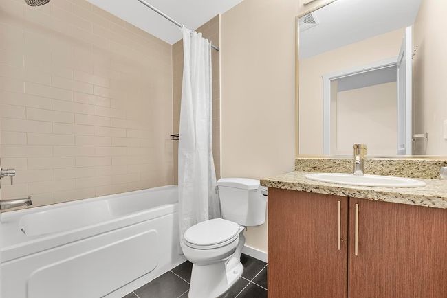 Bathroom featuring vanity, shower / bathtub combination with curtain, visible vents, tile patterned flooring, and toilet | Image 16