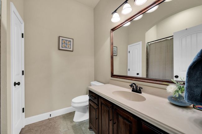 Bathroom featuring toilet, vanity, baseboards, tile patterned floors, and a shower with curtain | Image 24