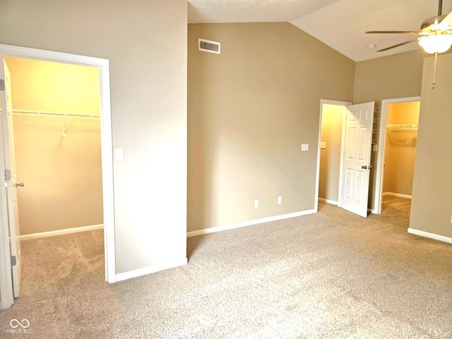 unfurnished bedroom with visible vents, a closet, carpet flooring, a spacious closet, and lofted ceiling | Image 28