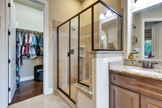 Full bath featuring a spacious closet, vanity, a stall shower, and tile patterned floors | Image 27