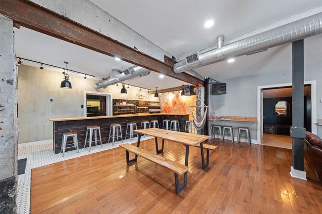 Dining area featuring baseboards, visible vents, a community bar, hardwood / wood-style floors, and track lighting | Image 11