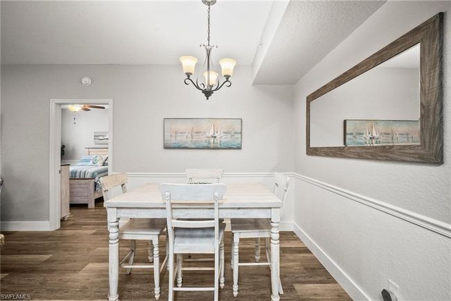 Dining room featuring baseboards, wood finished floors, and a chandelier | Image 25