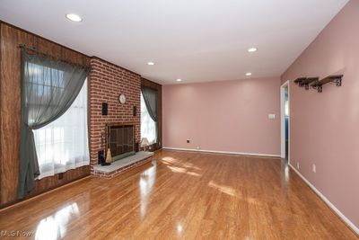 Unfurnished living room featuring hardwood / wood-style flooring and a fireplace | Image 3