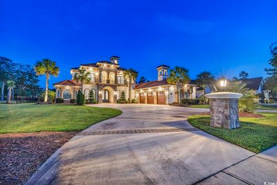 Mediterranean / spanish home with a garage and a yard | Image 1