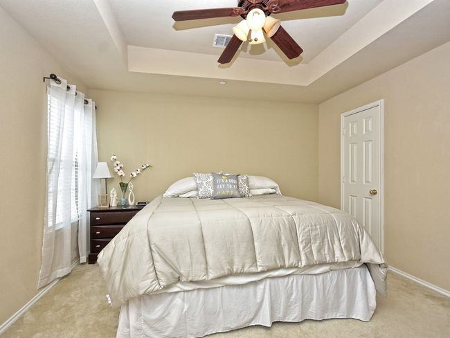 Bedroom featuring light carpet, baseboards, and a tray ceiling | Image 13