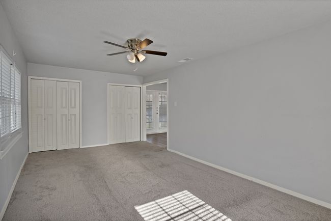 Unfurnished bedroom with two closets, visible vents, baseboards, and carpet | Image 11