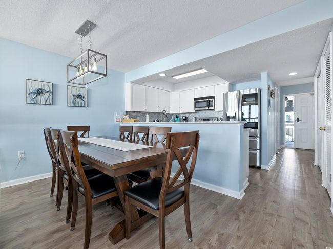 Dining space featuring baseboards, a textured ceiling, and wood finished floors | Image 9