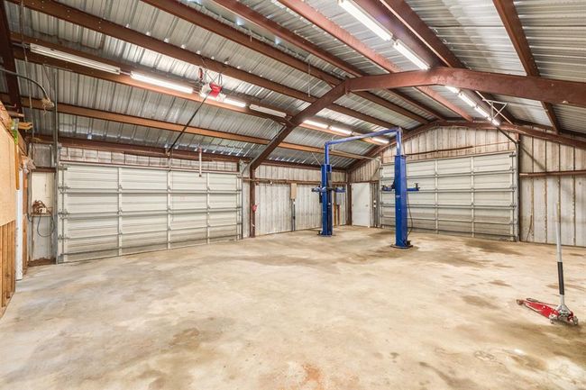 2 Double Garage Doors in this building. There may be parking available for 4 vehicles if you can get around the Lift. Vehicle Lift has not been used by current Owner, but it may be just the thing you need. Lift requires servicing. | Image 48