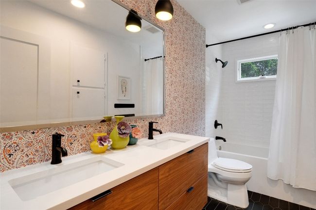 Hallway full bath featuring shower / tub combo and double vanity. | Image 26