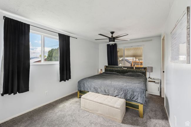 Bedroom with baseboards, a ceiling fan, carpet flooring, and multiple windows | Image 17