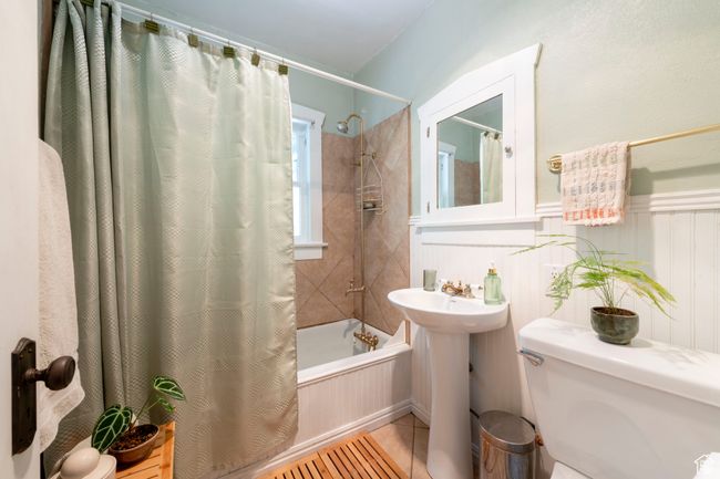 Bathroom featuring shower / bath combo with shower curtain, tile patterned floors, and a wainscoted wall | Image 16