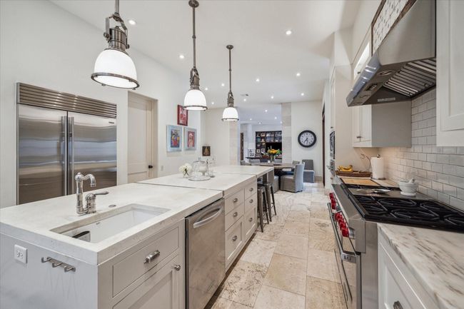 An amazing kitchen with poured concrete counters, subway tile backsplash, top-of-the-line stainless steel appliances, prep sink abd abundance of counter space and storage cabinets. | Image 17