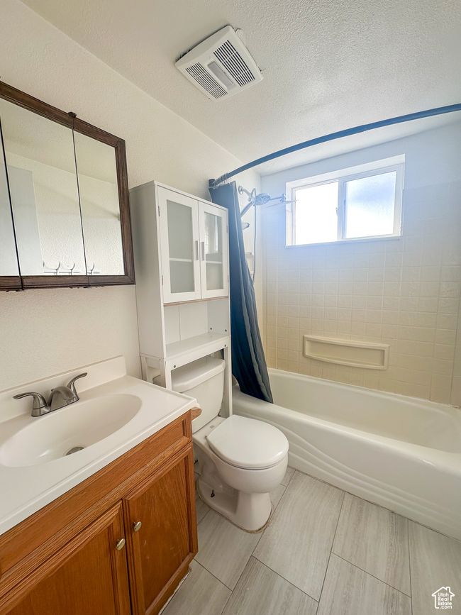 Full bathroom featuring vanity, shower / bath combo, and toilet | Image 14