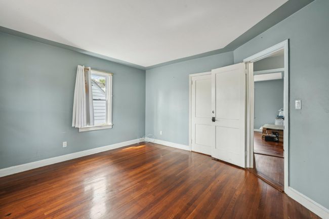 Unfurnished bedroom with baseboards and wood finished floors | Image 11
