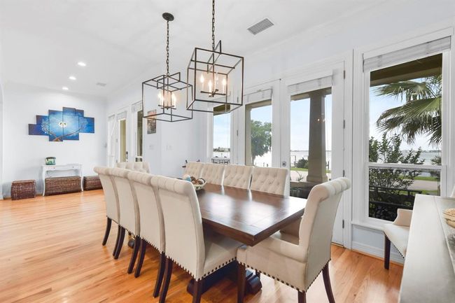 Bright and inviting dining room with stunning views, elegant lighting, and ample seating for gatherings. | Image 17