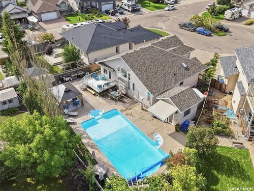 Expansive backyard featuring a swimming pool, paved patio, and a covered gazebo | Card Image