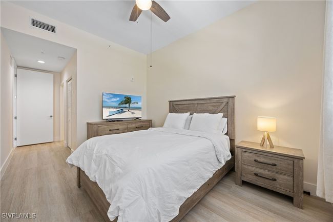 Bedroom featuring light wood-type flooring, a closet, a ceiling fan, and visible vents | Image 5