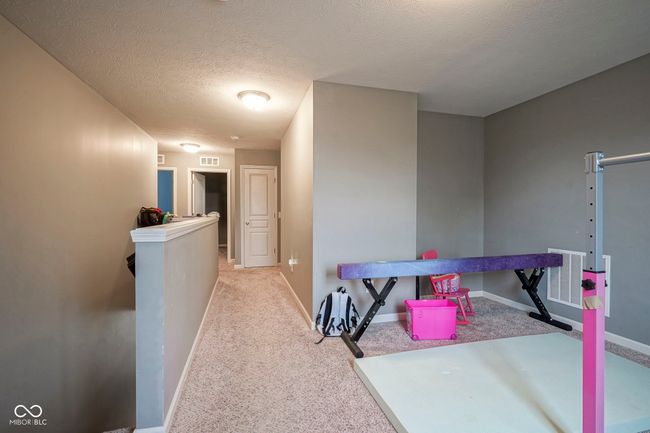 corridor with carpet flooring, baseboards, an upstairs landing, and a textured ceiling | Image 28