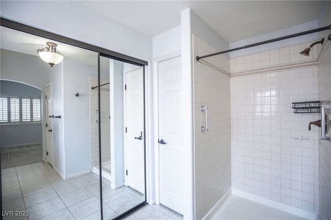 Bathroom with tile patterned floors, a shower stall, and a closet | Image 21